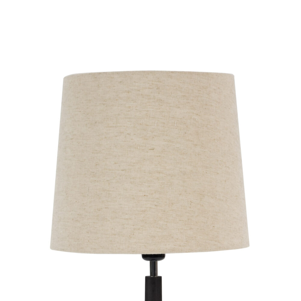 A beige linen drum lampshade on a black lamp base, shown against a plain white background.
