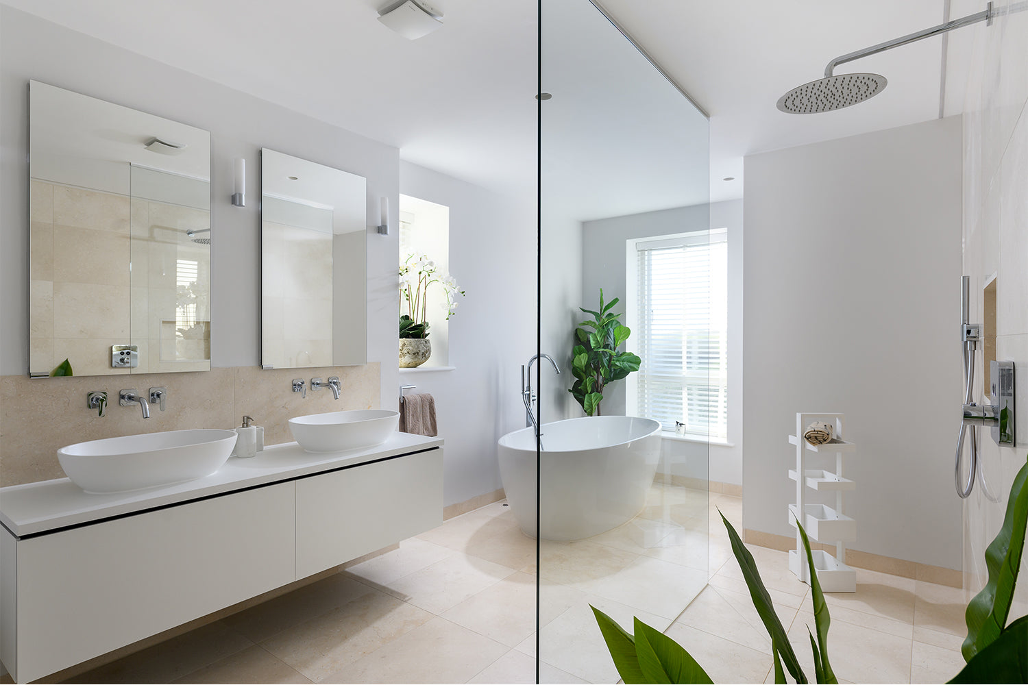 Luxury contemporary bathroom at Paradise View featuring dual vessel sinks, wall-mounted taps, freestanding oval bathtub, walk-in rainfall shower, and soft neutral tiling – styled by Iroka Interiors.