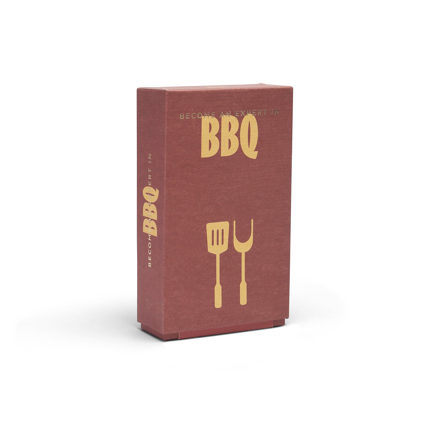 A rectangular reddish-brown box with gold 'BBQ' lettering and a gold spatula-and-fork graphic on the front, shown on a clean white background.