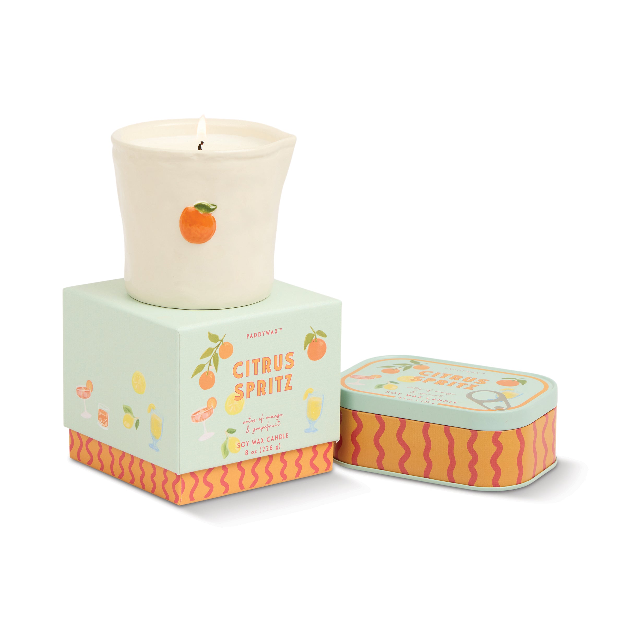 Candle in a decorative tin with citrus design on a white background