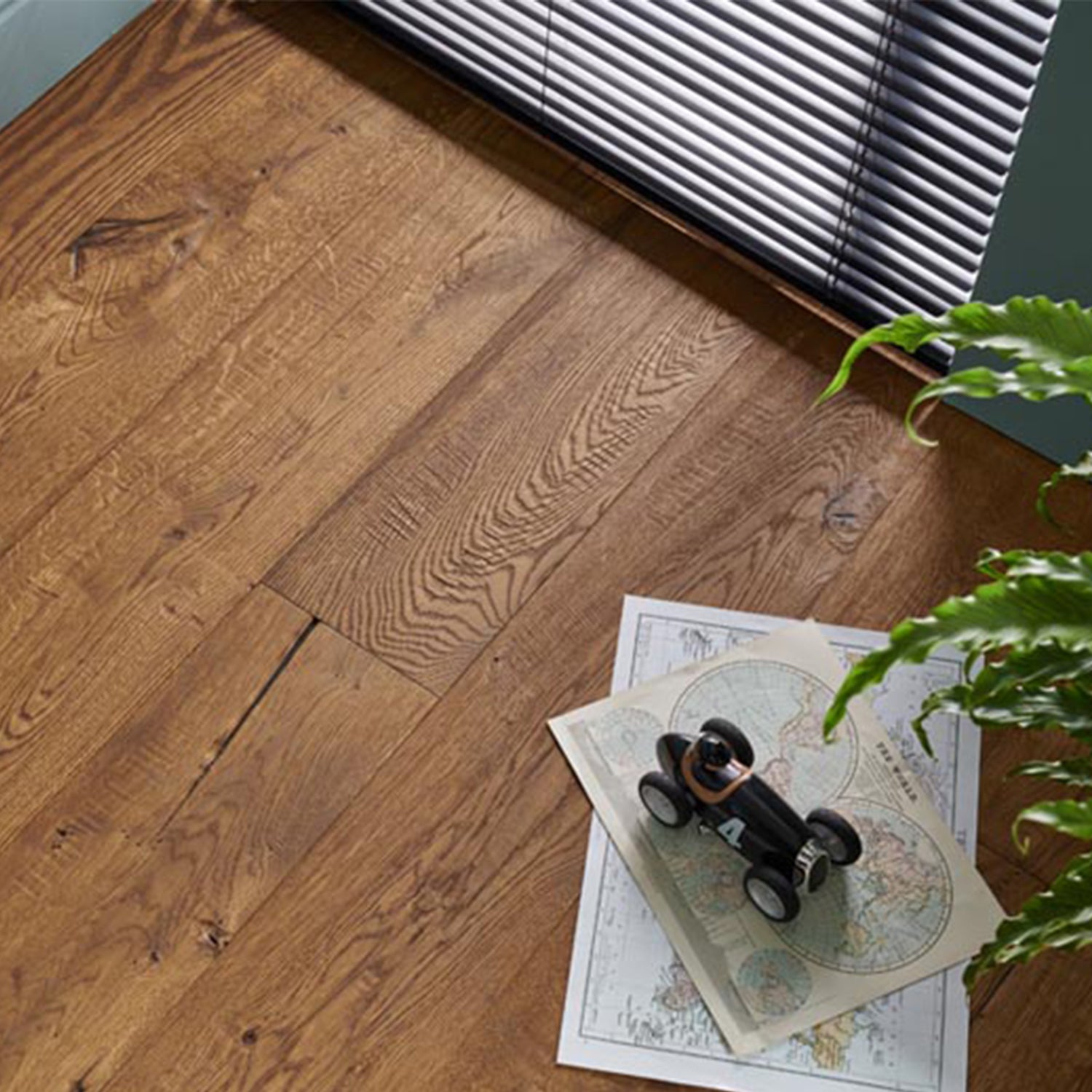 Berkeley Cathedral engineered wood flooring in a rich oak finish, shown with vintage toy car and world maps for a classic and characterful interior detail.