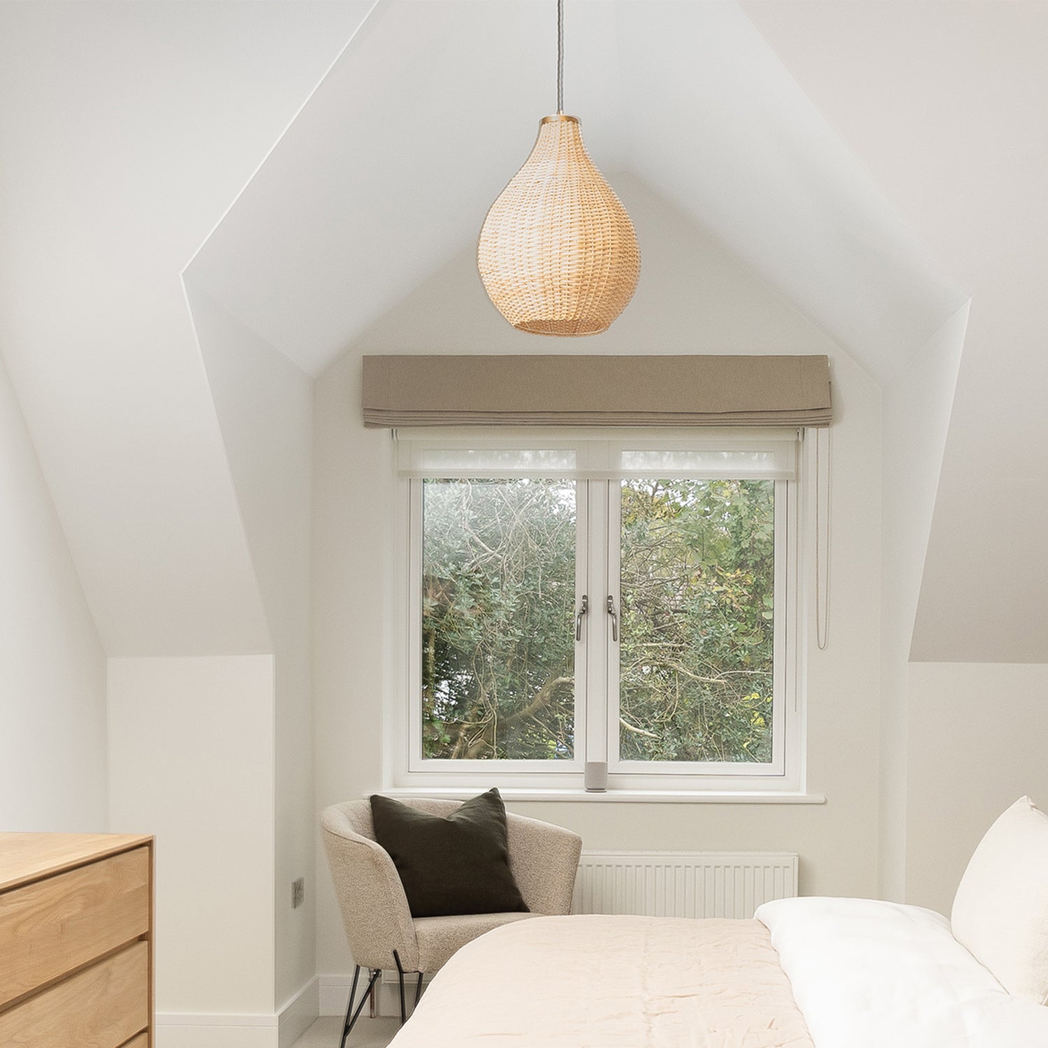 Neutral Roman blinds with sheer roller blinds layered underneath in a modern Cornwall bedroom by Iroka Interiors
