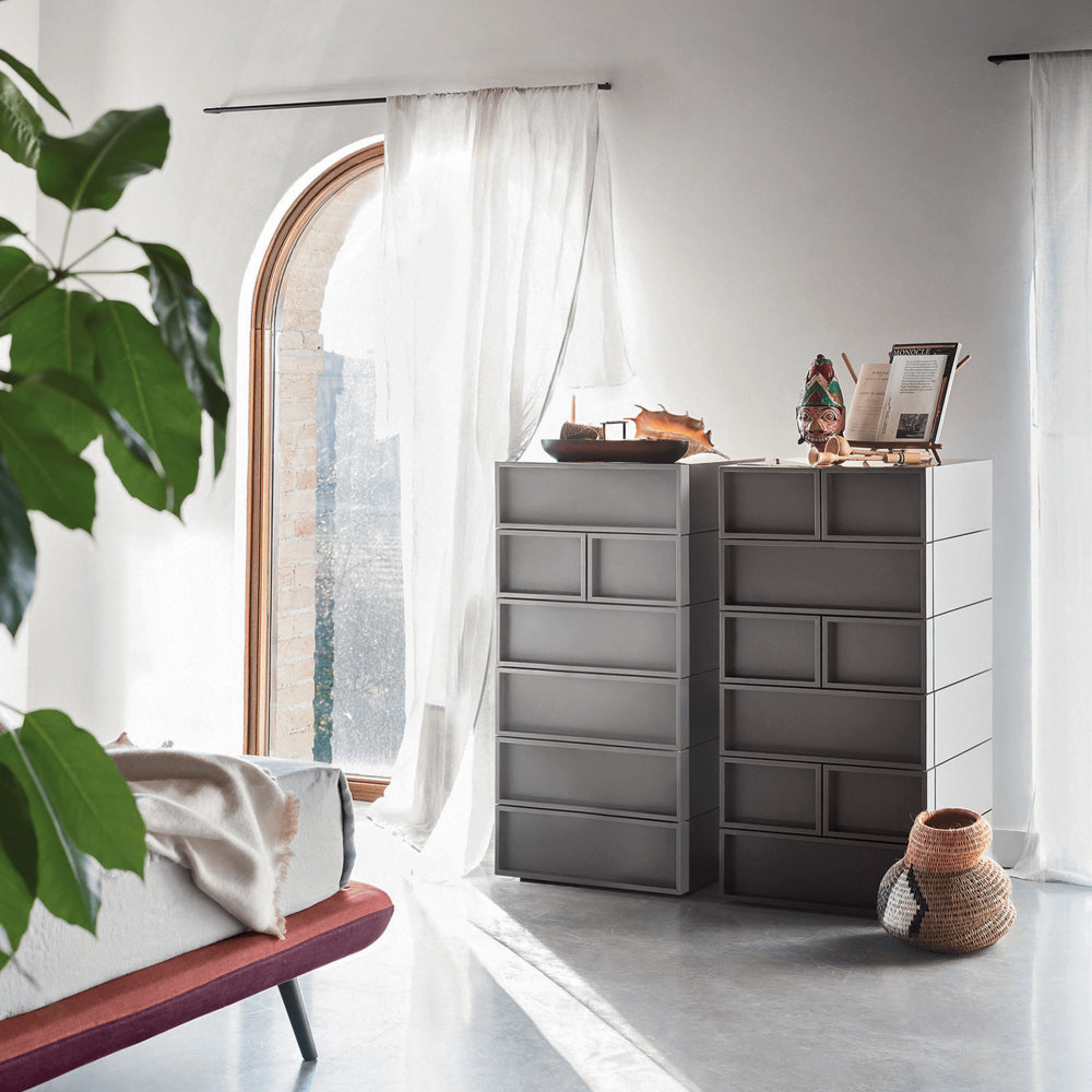 Cube System by Novamobili – sleek modular drawer units in matte grey with geometric handle design, ideal for modern bedroom or living space storage – styled in natural light near arched window, available at Iroka Interiors Cornwall.
