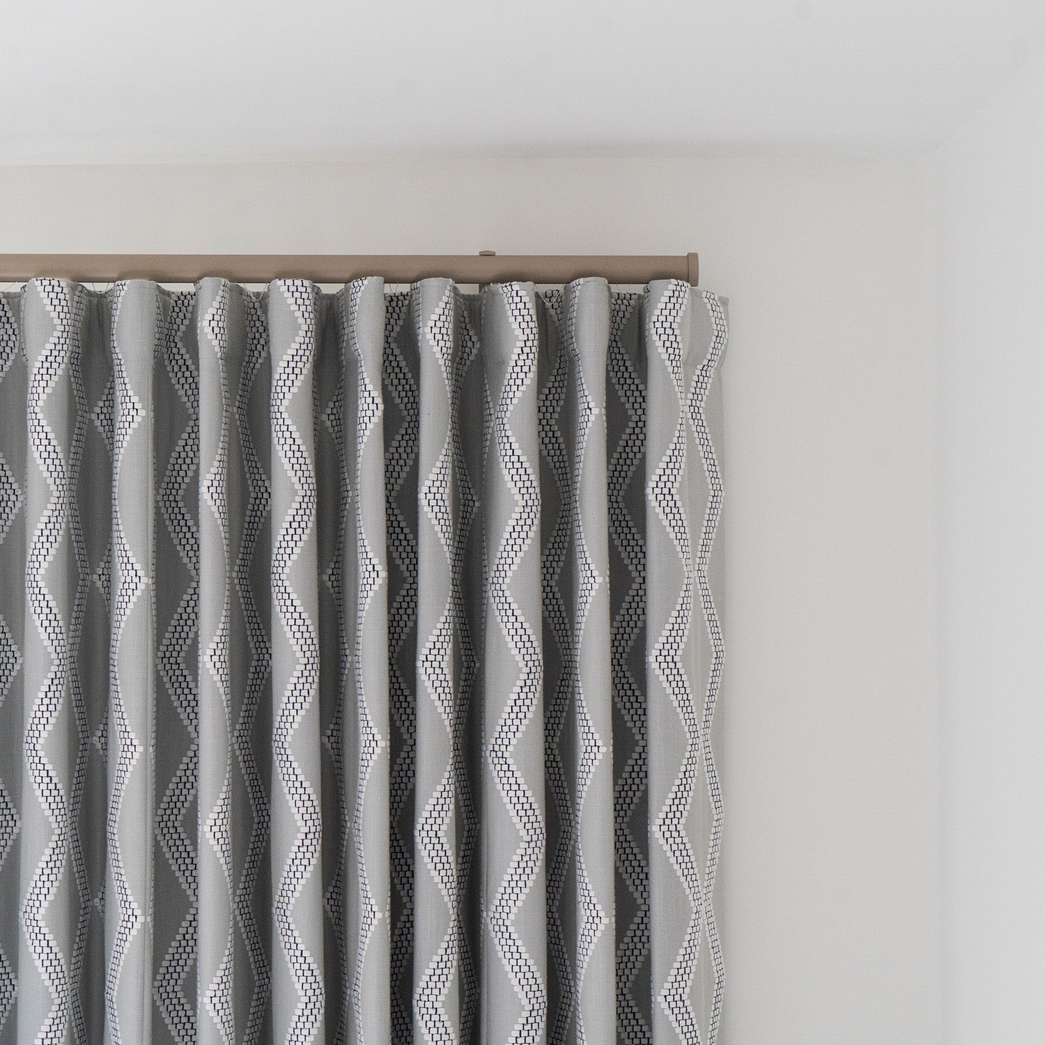Contemporary wave curtains in textured grey fabric, mounted on a sleek ceiling track