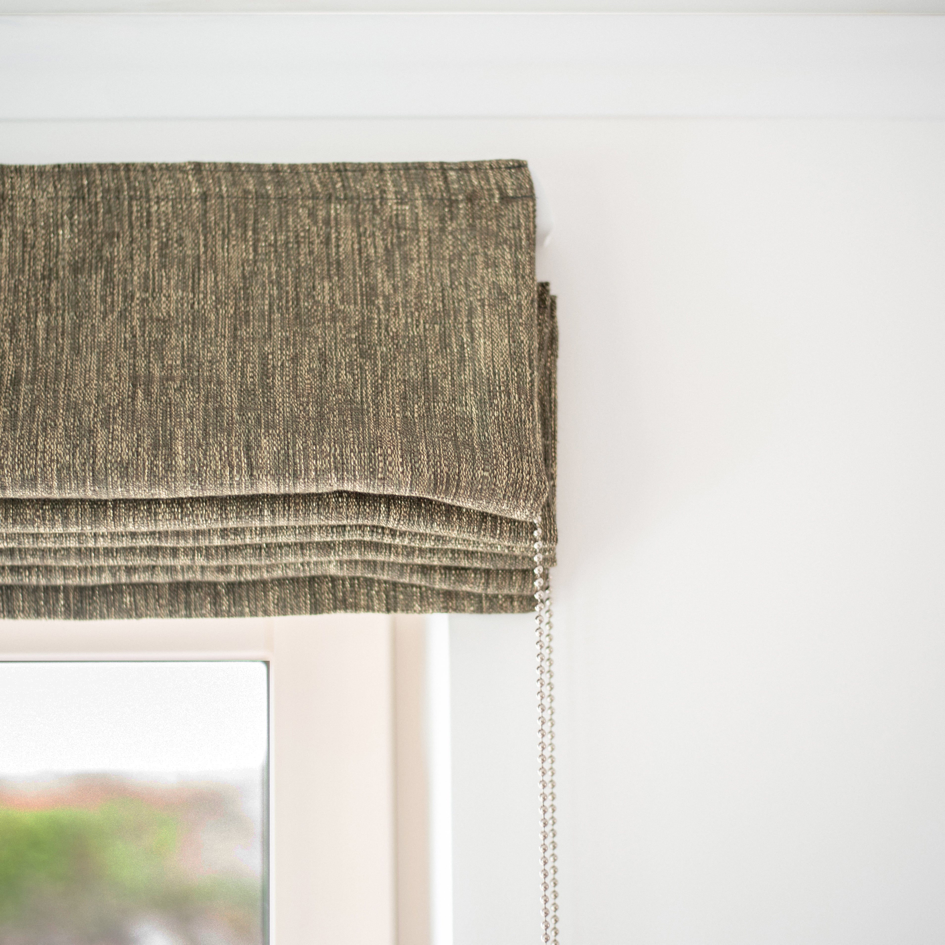 Textured Roman blind in rich olive fabric with chain mechanism, designed and installed by Iroka Interiors in Cornwall for bespoke window dressing solutions.