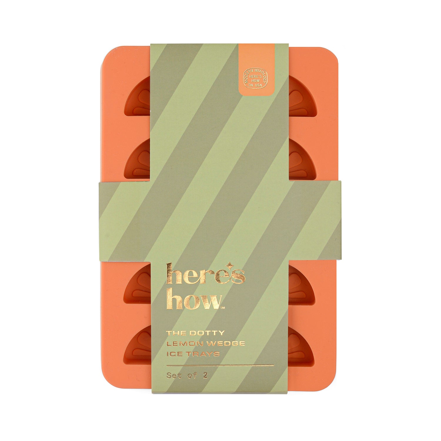 A set of two orange silicone ice trays with a dotted pattern, packaged in a striped green and beige box with the text 'here's how' on the front.