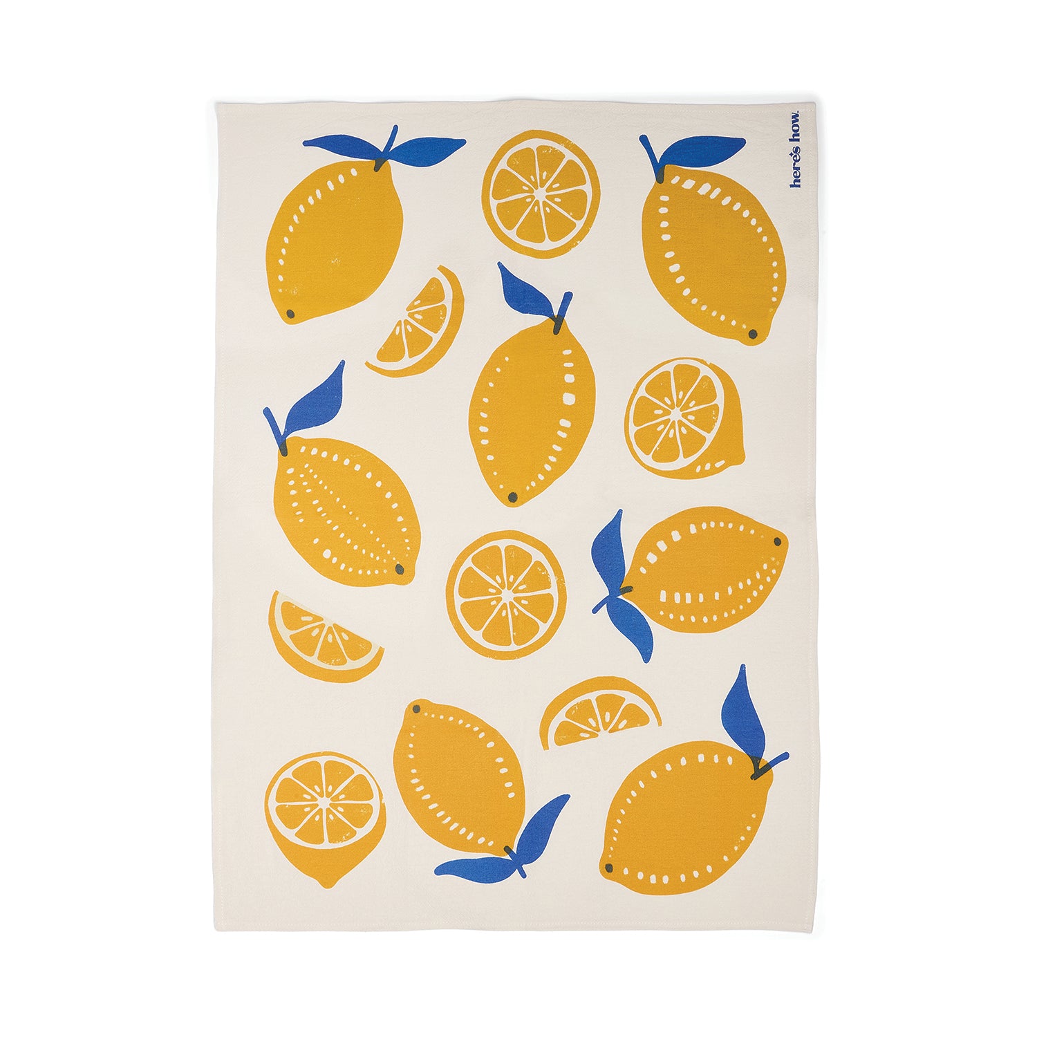 An off-white tea towel featuring a playful pattern of yellow lemons in whole and sliced forms, accented with blue leaves.