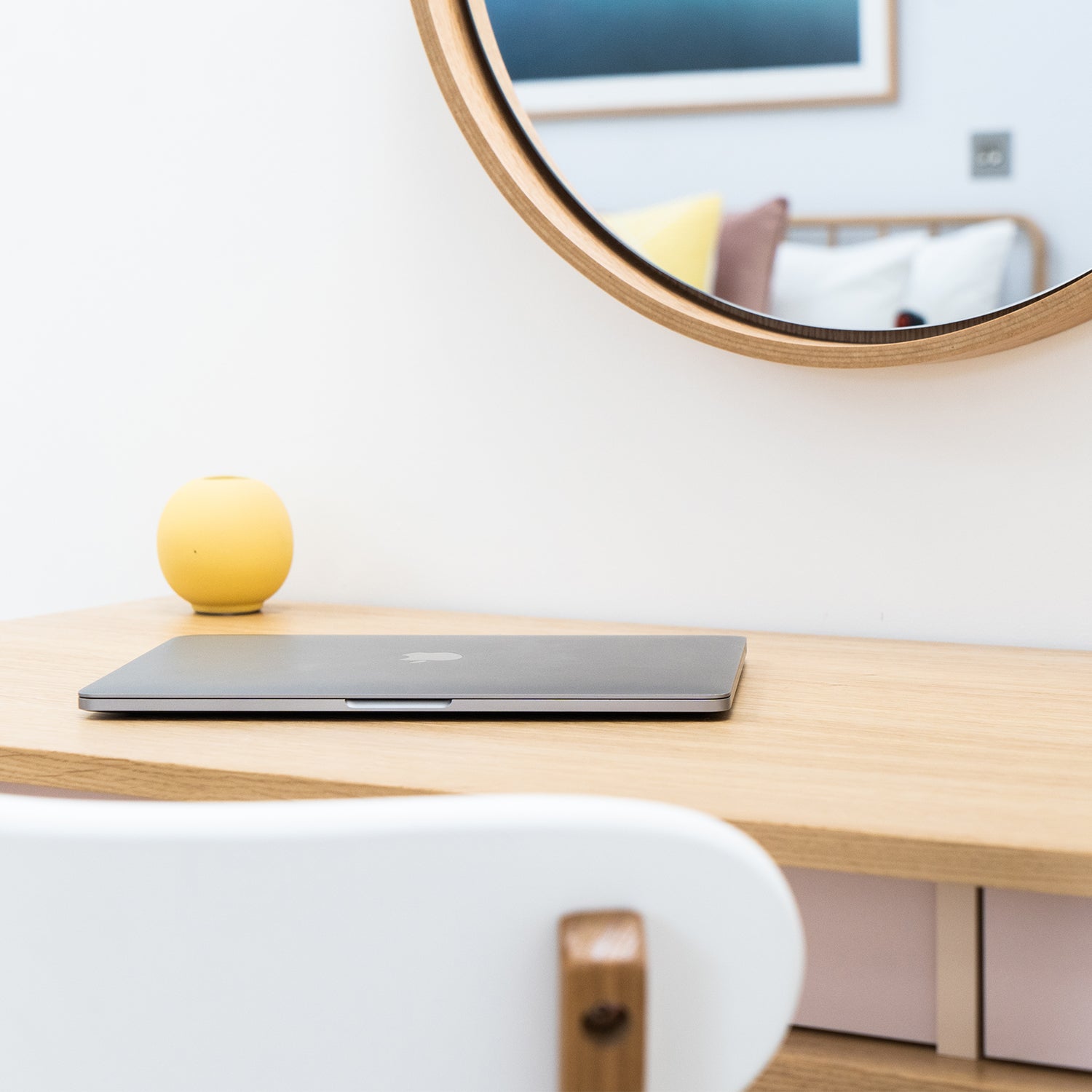 Minimalist hotel workspace with Scandinavian-style wooden desk, white chair, and round wall mirror – interior design by Iroka Interiors in Cornwall, tailored for modern hospitality environments and boutique accommodations.