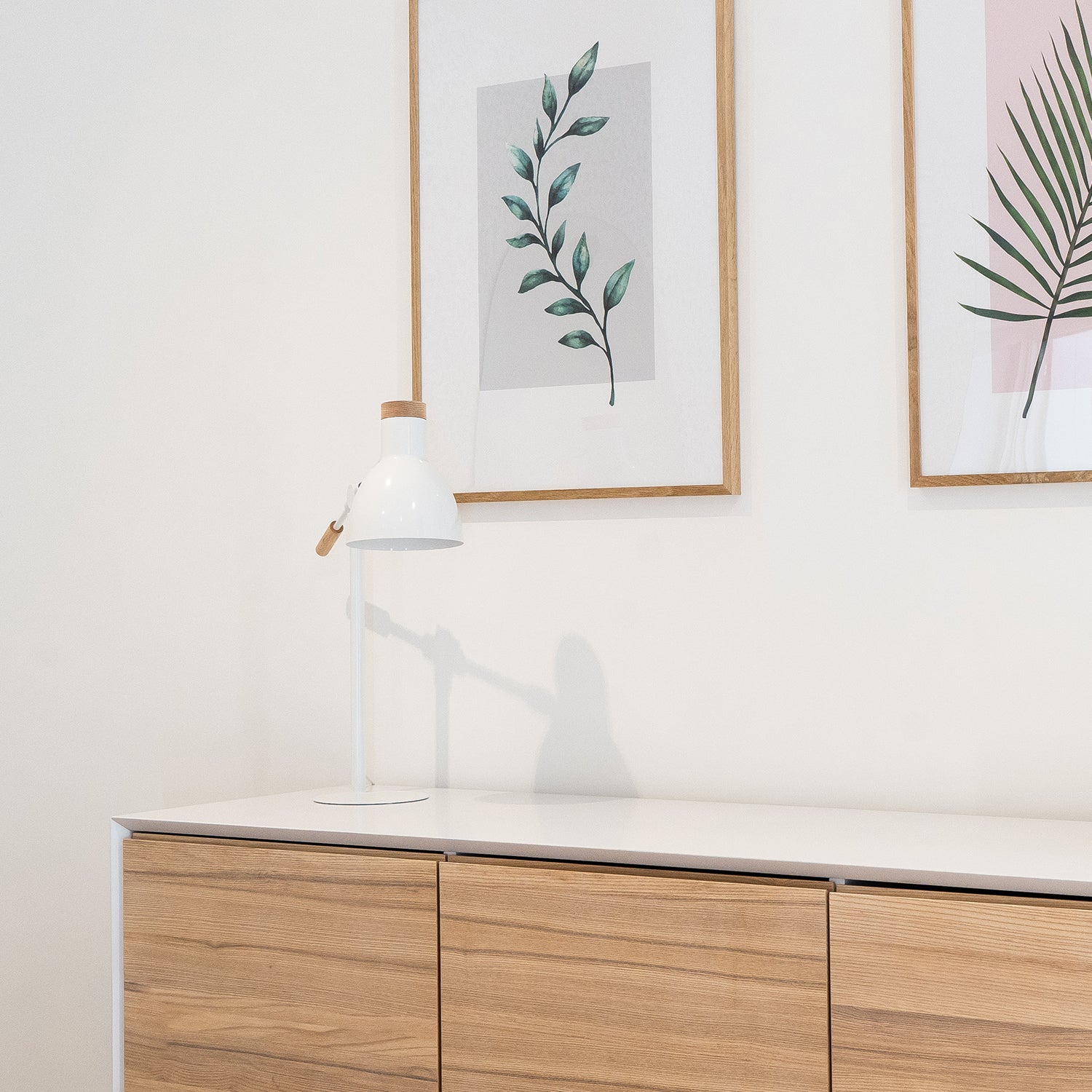 Scandinavian-style hotel interior with natural oak dresser, minimalist white ceramic vase, and botanical wall art – designed by Iroka Interiors for elegant hospitality spaces in Cornwall.