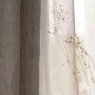 Close-up of layered sheer and textured linen curtains in neutral tones with delicate dried florals—premium soft furnishings