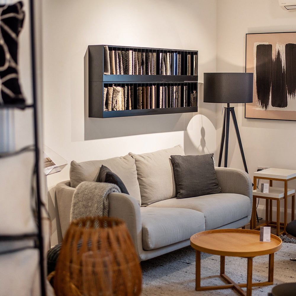 Living room with a sofa, coffee table, bookshelf, and wall art.