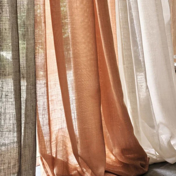 Layered sheer Casamance Lyrique curtains in earthy taupe, terracotta, and ivory tones, to create soft natural light and elegant texture.