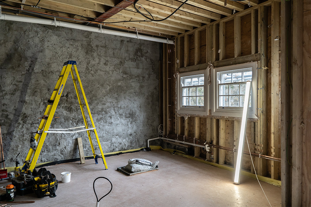 Kitchen renovation in progress with exposed timber framing, concrete wall, and electrical setup – professional kitchen design and installation service in Cornwall by Iroka Interiors.