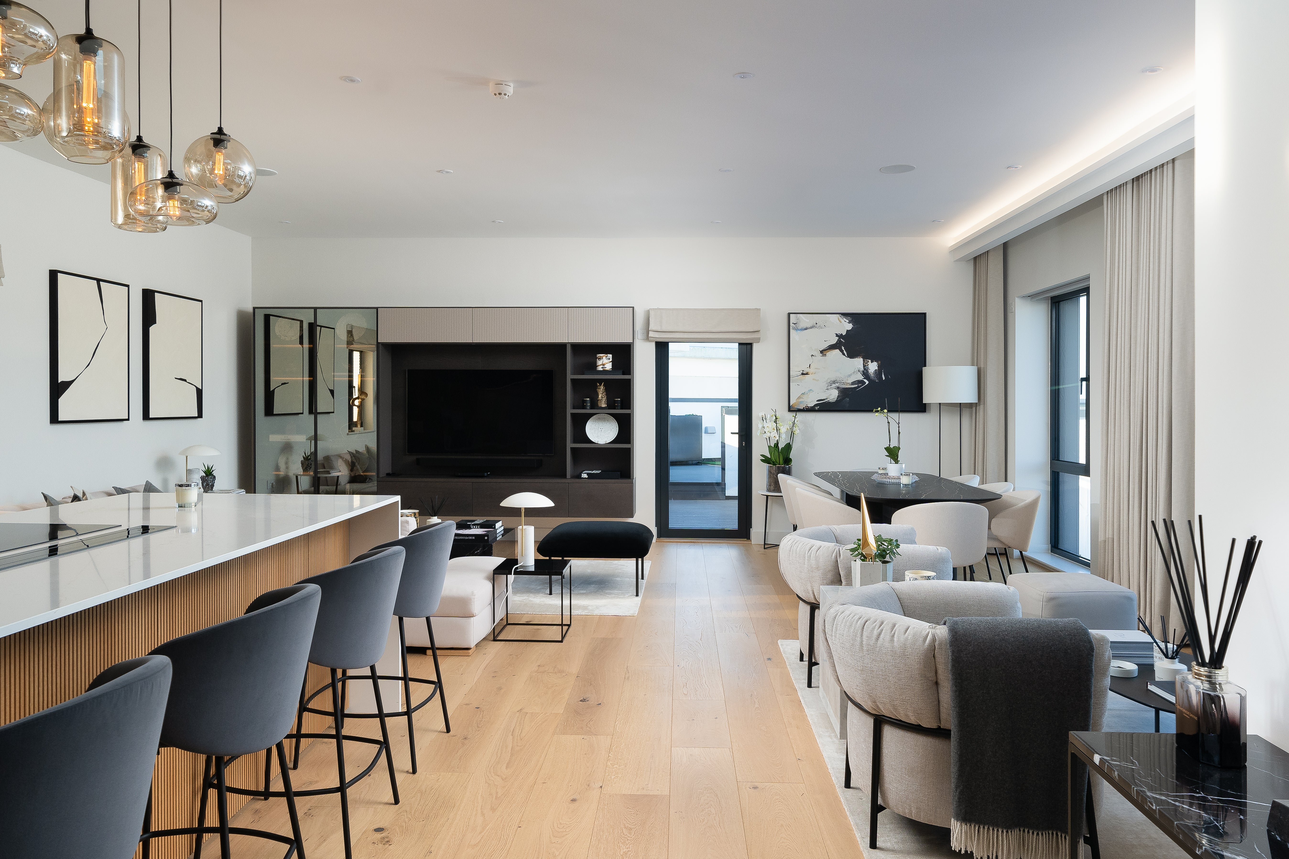 Luxury open-plan living space in the Pentire Penthouse, Newquay – featuring contemporary kitchen with marble island, designer lighting, and elegant coastal-inspired interiors by Iroka Interiors.