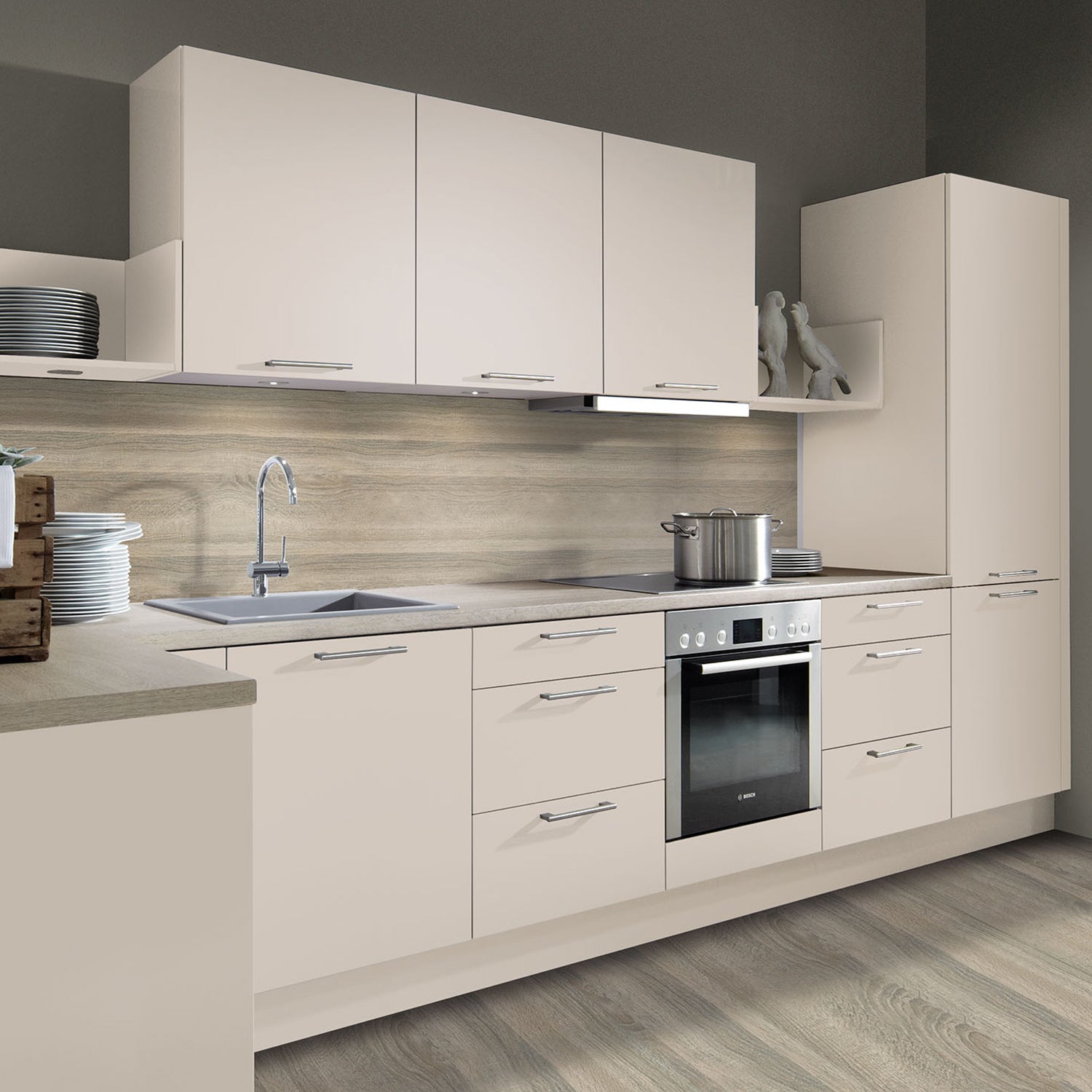 Modern German Schröder kitchen in soft matte beige finish with integrated appliances, minimalist handleless cabinetry, and sleek tiled backsplash – elegant and functional kitchen design by Iroka Interiors, Cornwall.