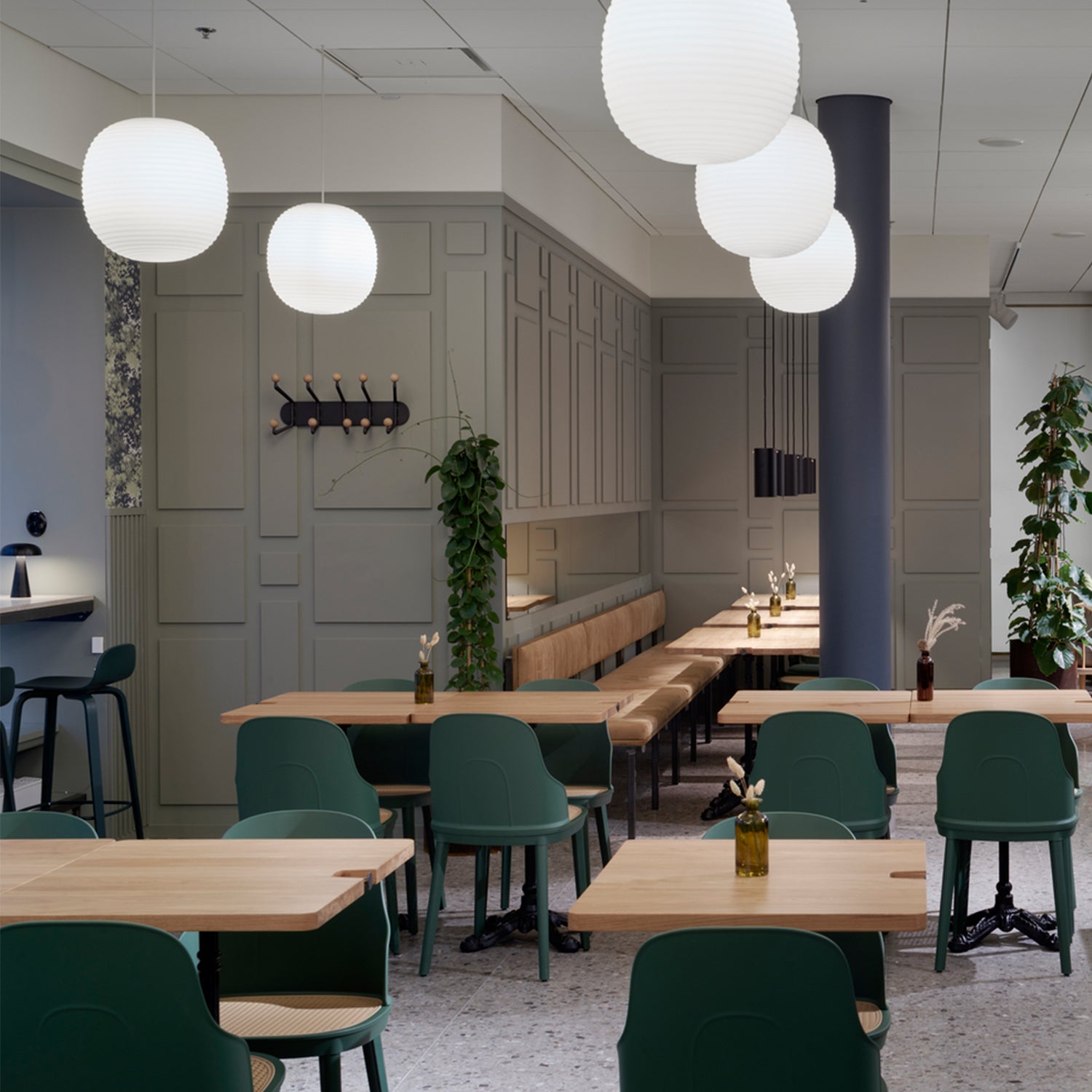 Modern contract interior design for a commercial restaurant in Cornwall by Iroka Interiors – featuring green dining chairs, pale wood tables, soft wall panelling, and ambient pendant lighting for a stylish and welcoming hospitality space.