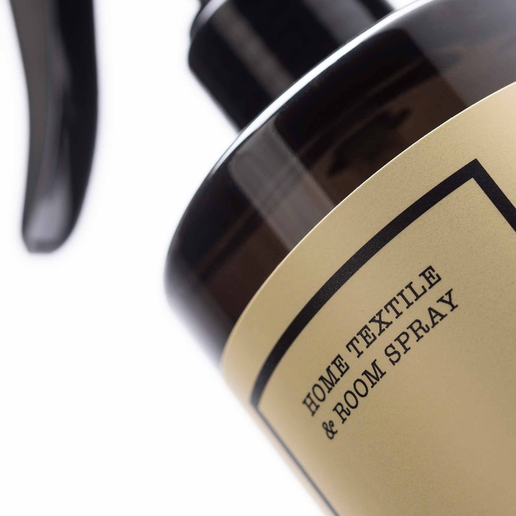 Home textile and room spray bottle with a gold label on a white background