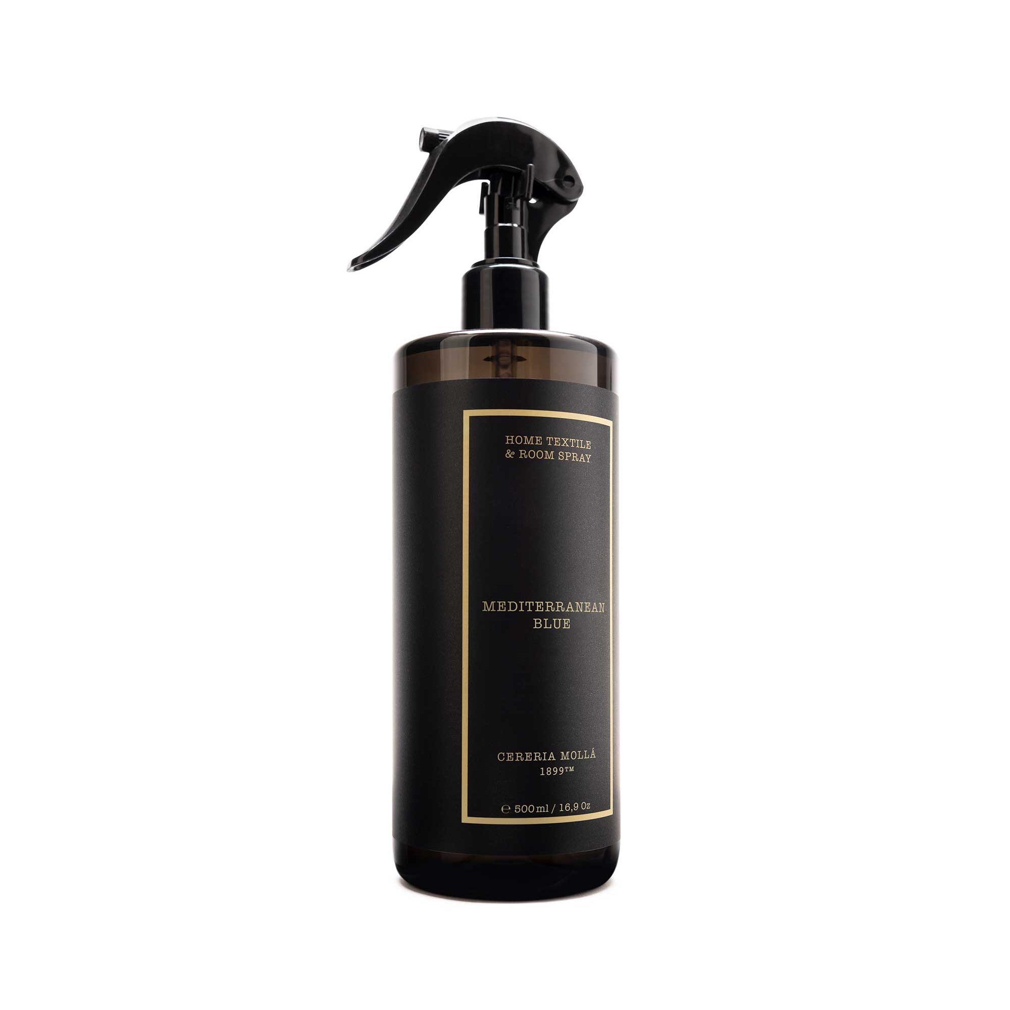 A dark brown glass spray bottle with a black trigger sprayer and a black label featuring gold text, set against a plain white background.