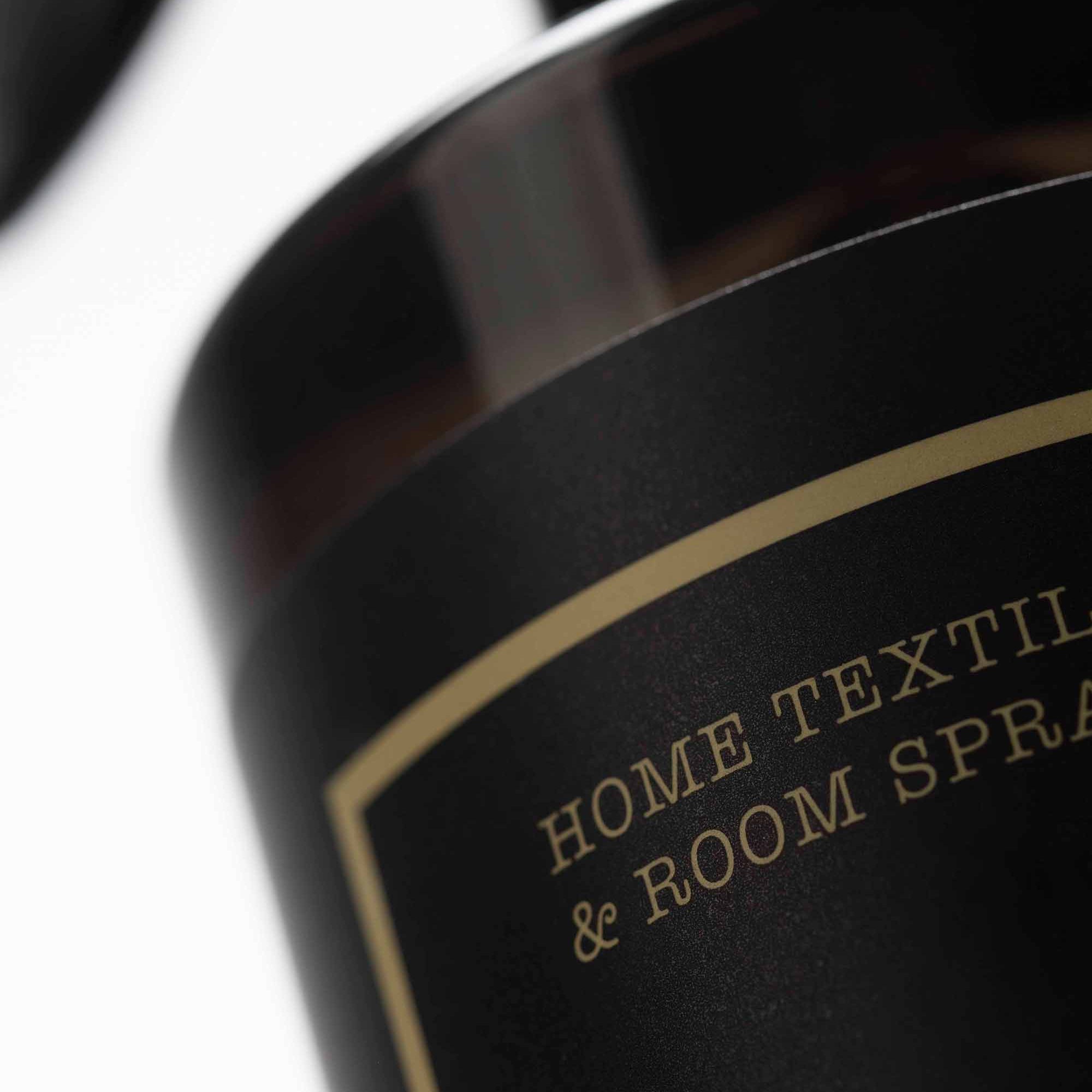 Close-up of a black bottle with gold text on a white background