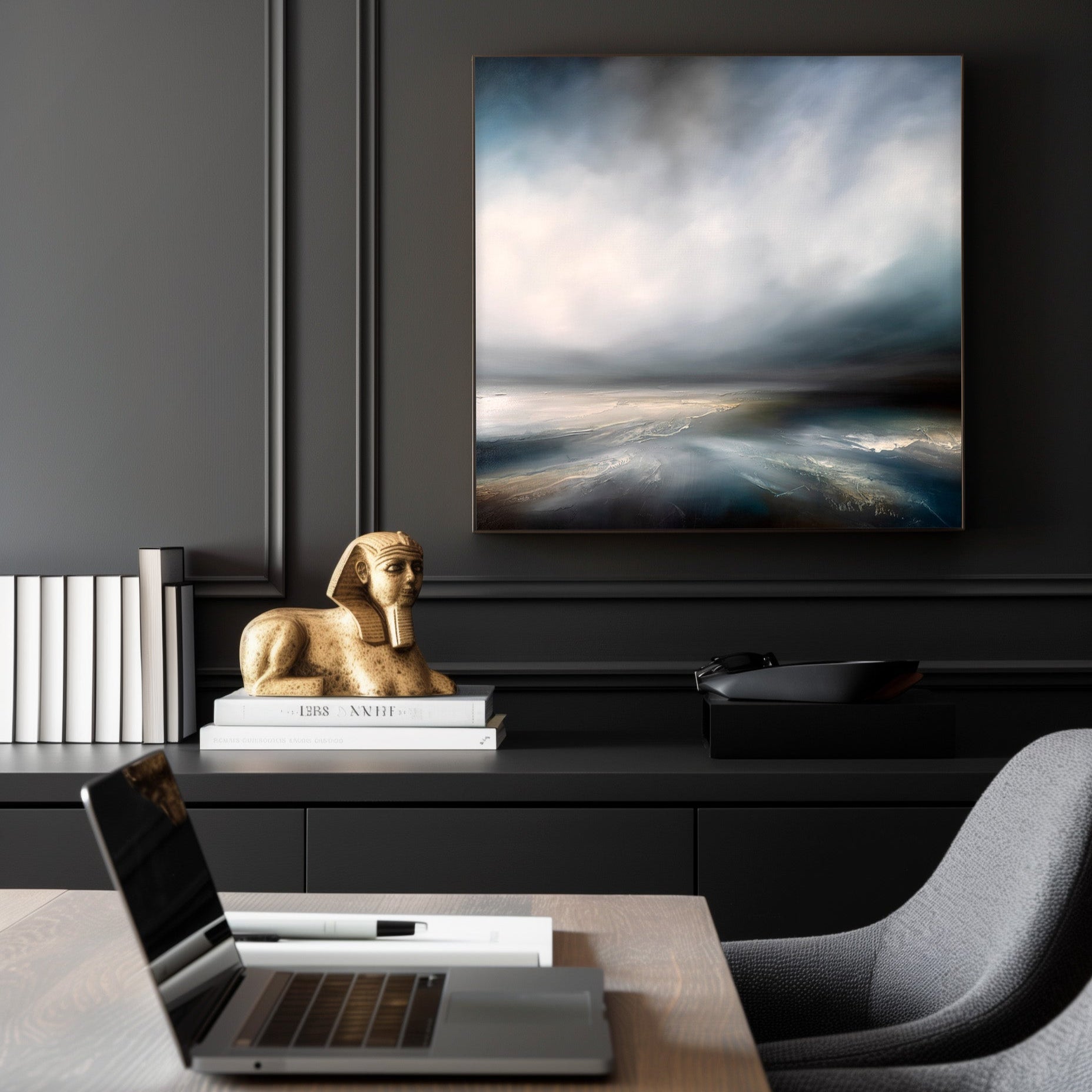 Modern office setup with a laptop on a desk, framed artwork on the wall, and decorative items.