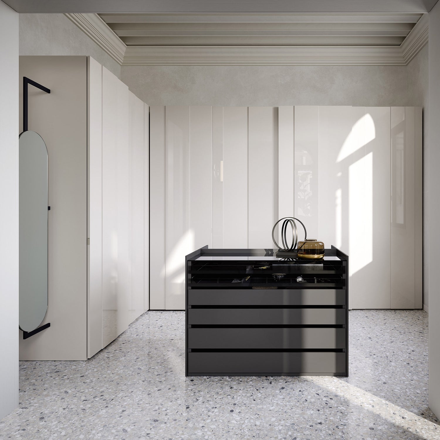 Luxury fitted walk-in wardrobe featuring black glass drawer island, sleek floor-to-ceiling cabinetry, and marble flooring – bespoke storage solution by Iroka Interiors, Cornwall, combining elegance and functionality for premium bedroom spaces.