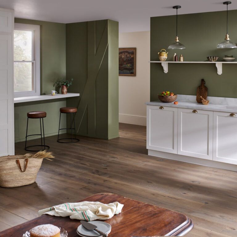 Berkeley Calico engineered wood flooring in a traditional kitchen with olive green walls, shaker cabinets and marble countertops for a warm, rustic-modern look.