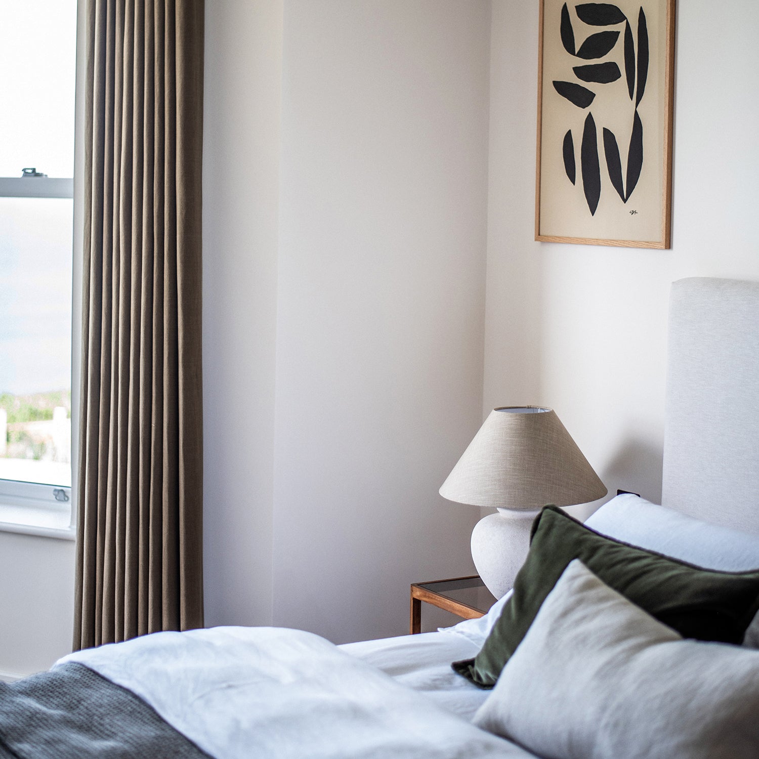 Elegant floor-length blackout curtains in a modern neutral bedroom by Iroka, designed for light control and refined coastal comfort.