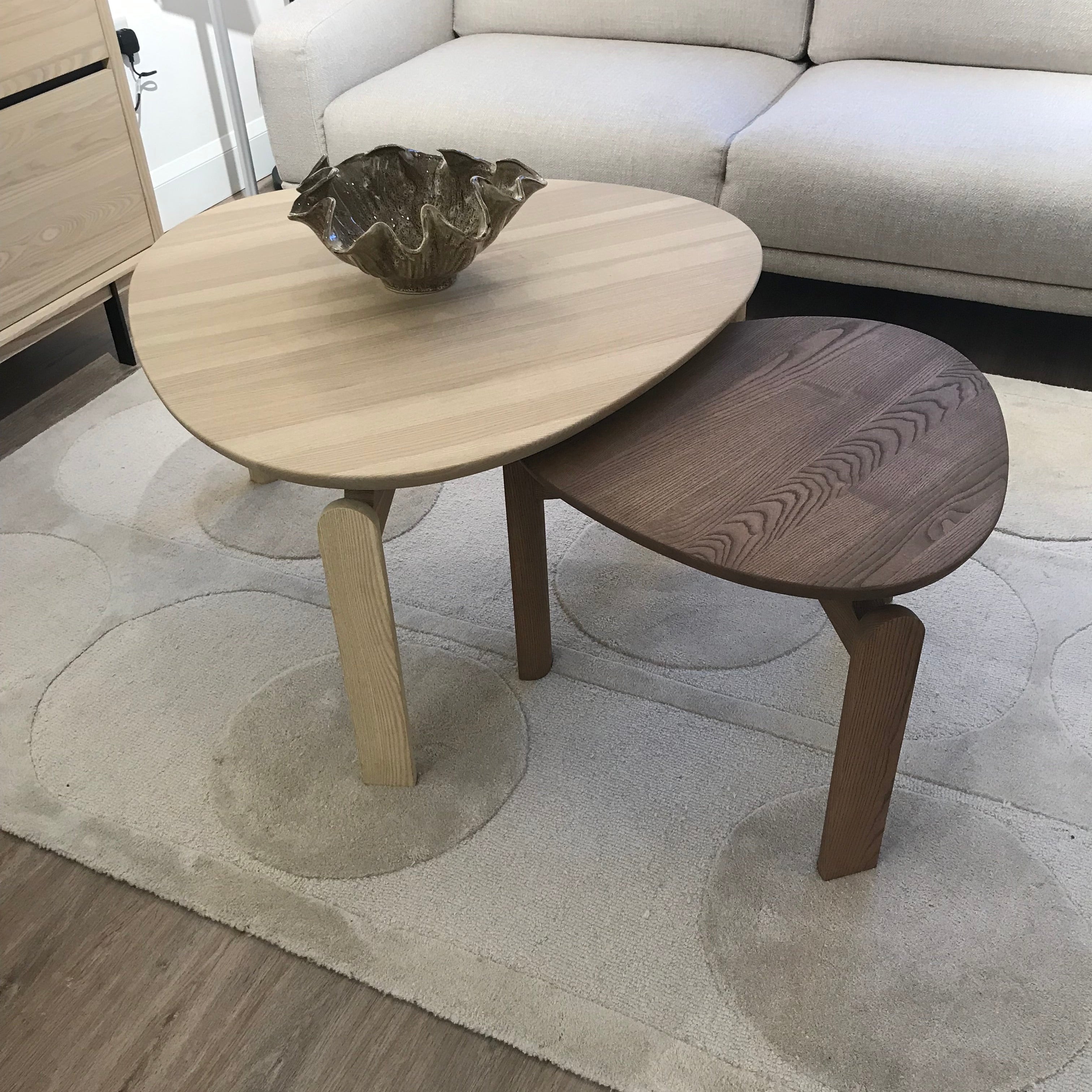 Wooden chair with a round seat and backrest on a patterned rug.