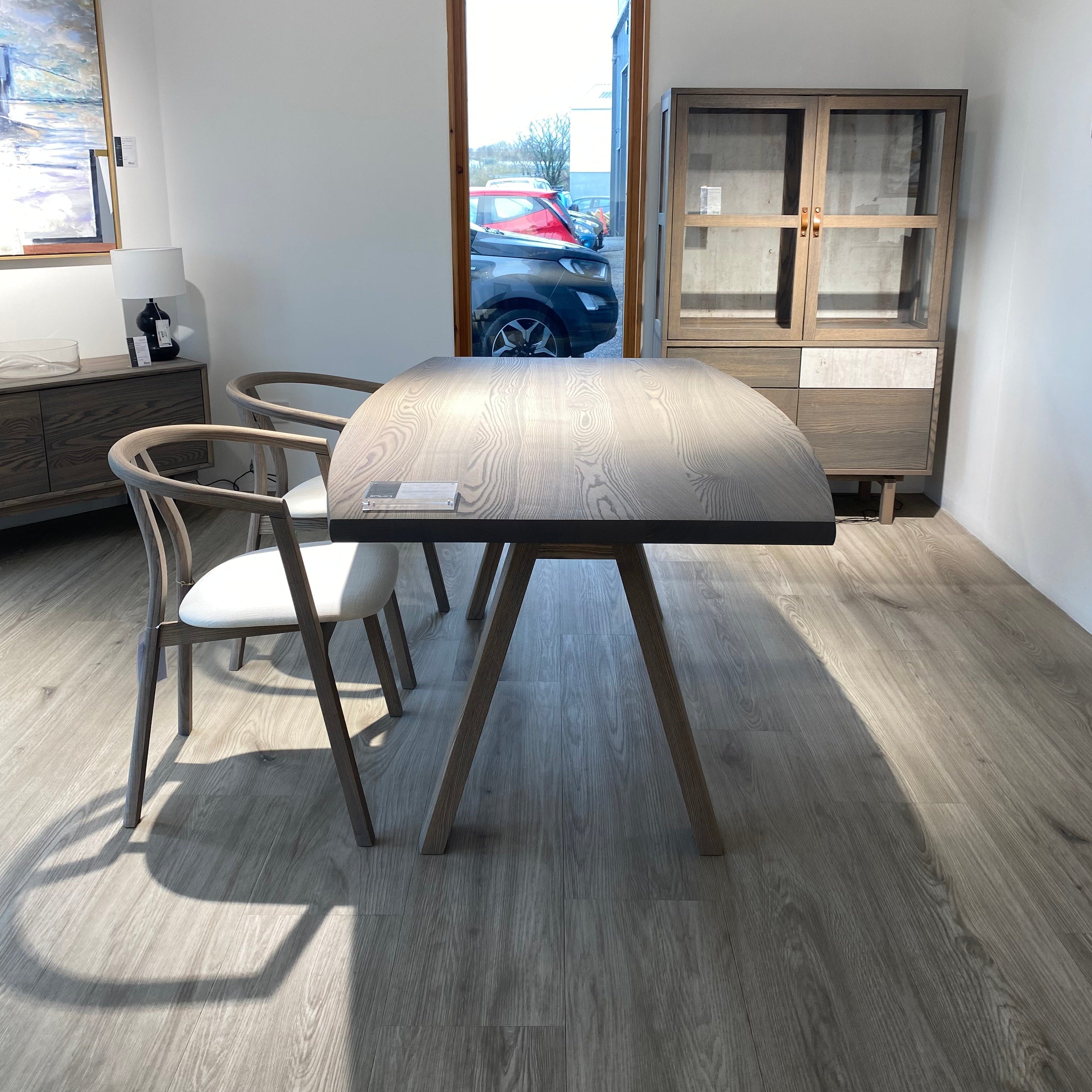 Modern dining room with a round table and chairs on a wooden floor.