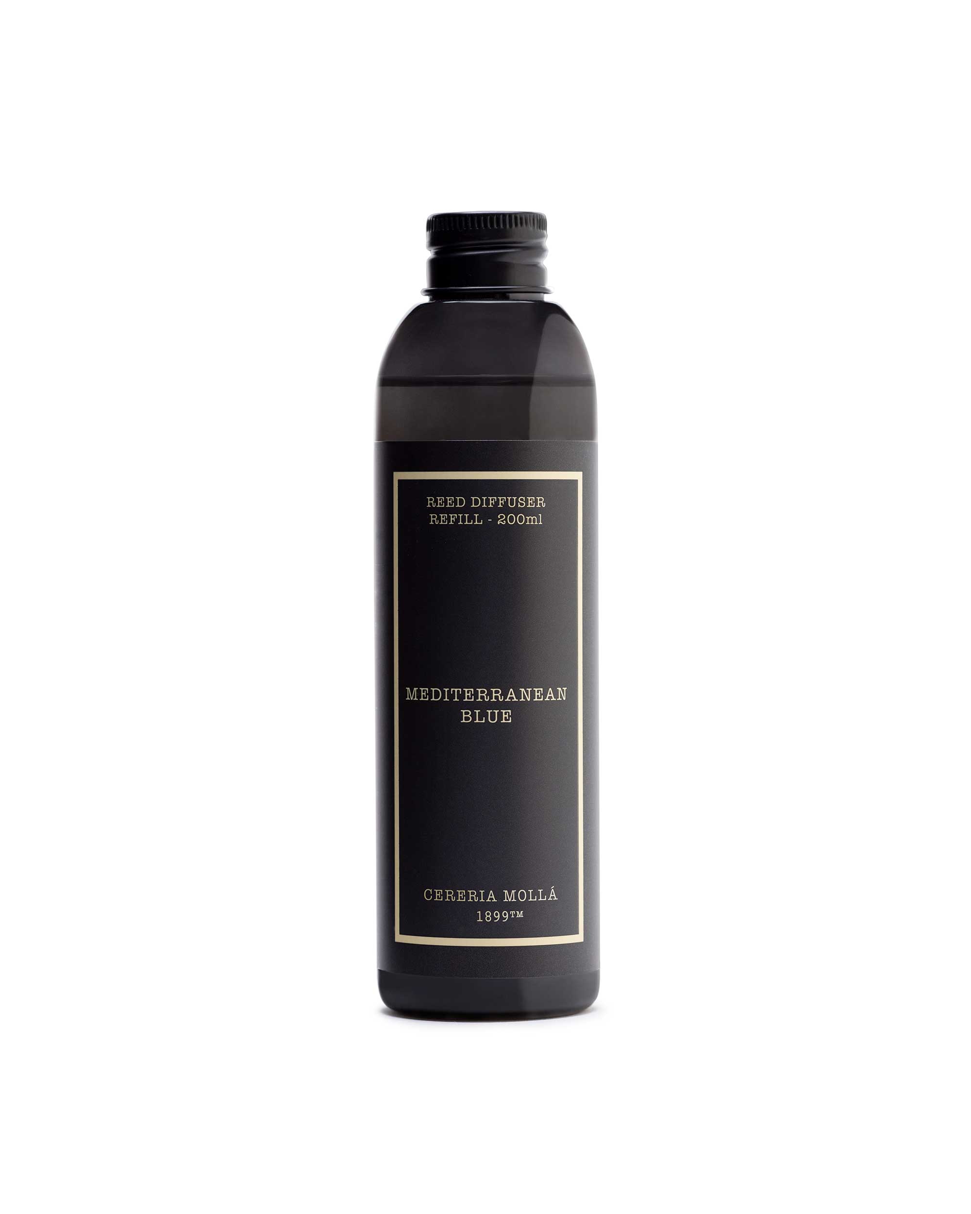 A dark brown glass bottle of Cereria Molla 'mediterranean blue' reed diffuser liquid, featuring a black label with gold lettering, on a solid white background.