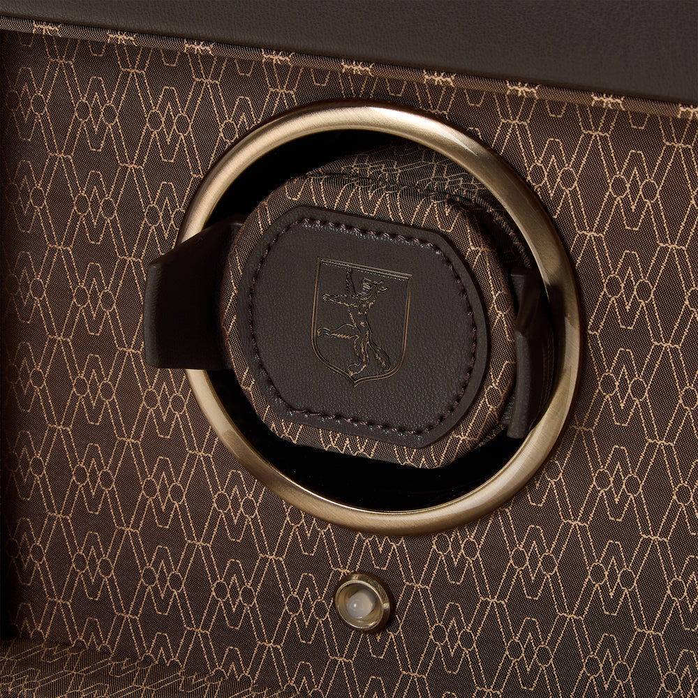 Close-up of a brown leather strap with a metal ring on a textured brown background