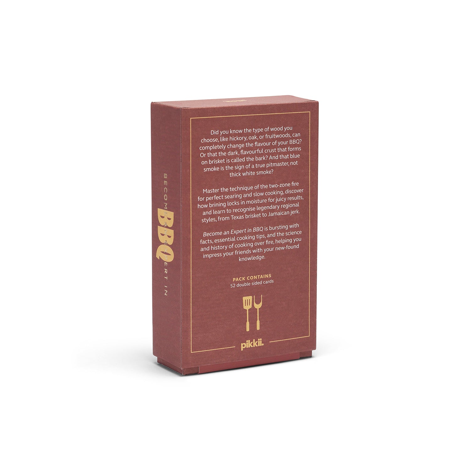 A tall, rectangular reddish-brown box with gold text and a small logo at the bottom, photographed upright on a clean white background. The front panel contains descriptive text about BBQ smoking techniques, and the side shows the brand name 'Pikél' and 'DECADENT'.