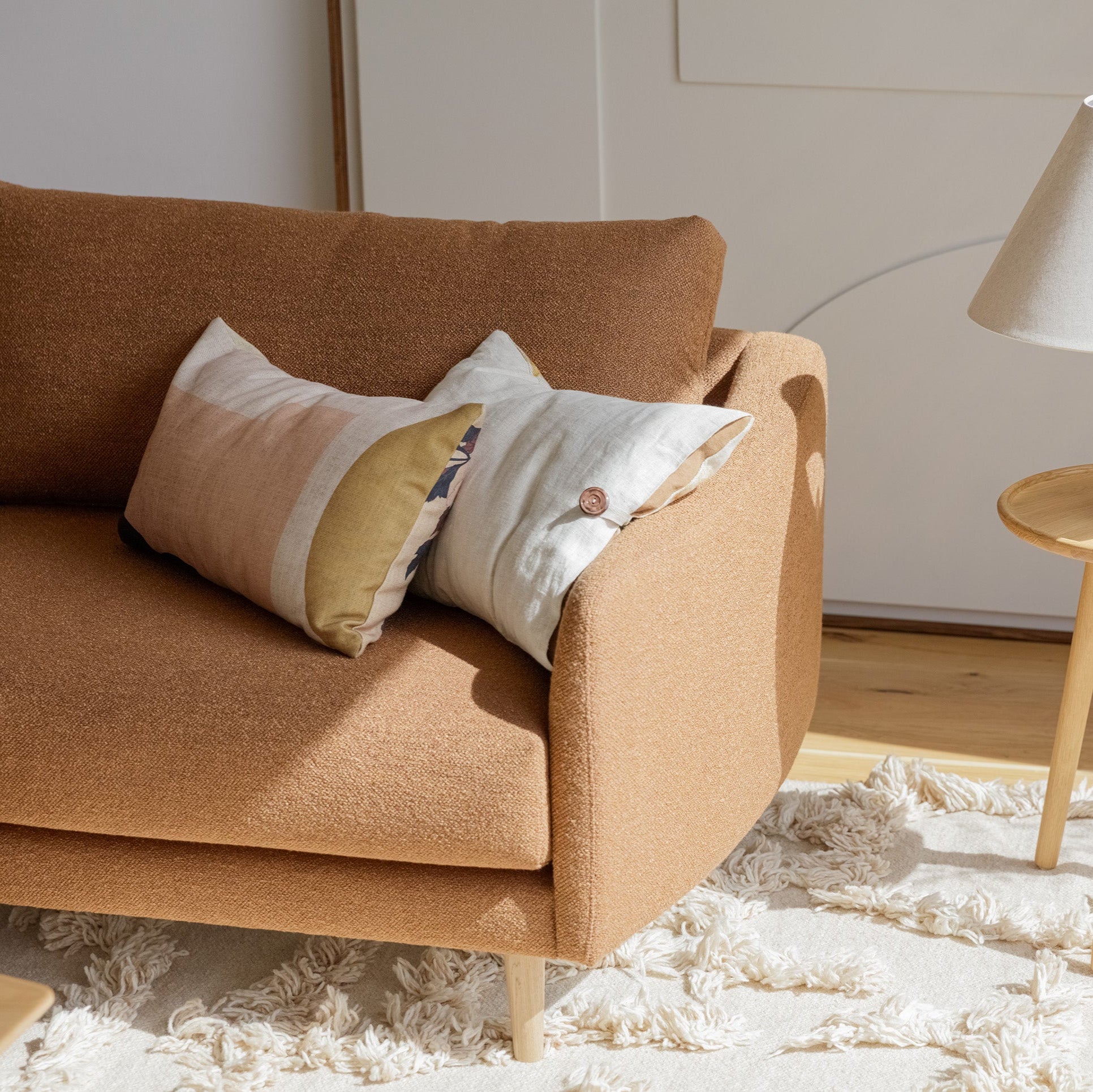 Mastrella Billie Sofa in Brown soft fabric. Placed in living room with minimalistic and warm styling.