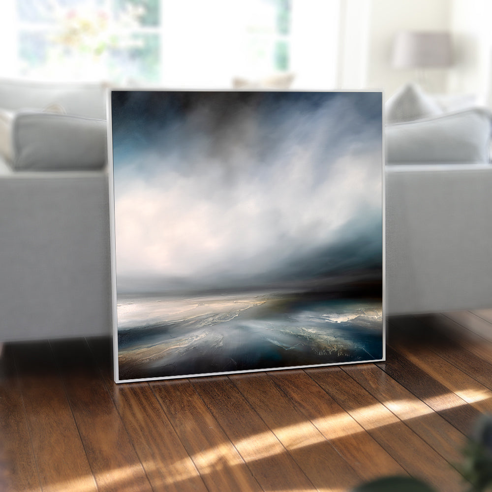 Framed artwork of a landscape with clouds on a wall in a modern living room.