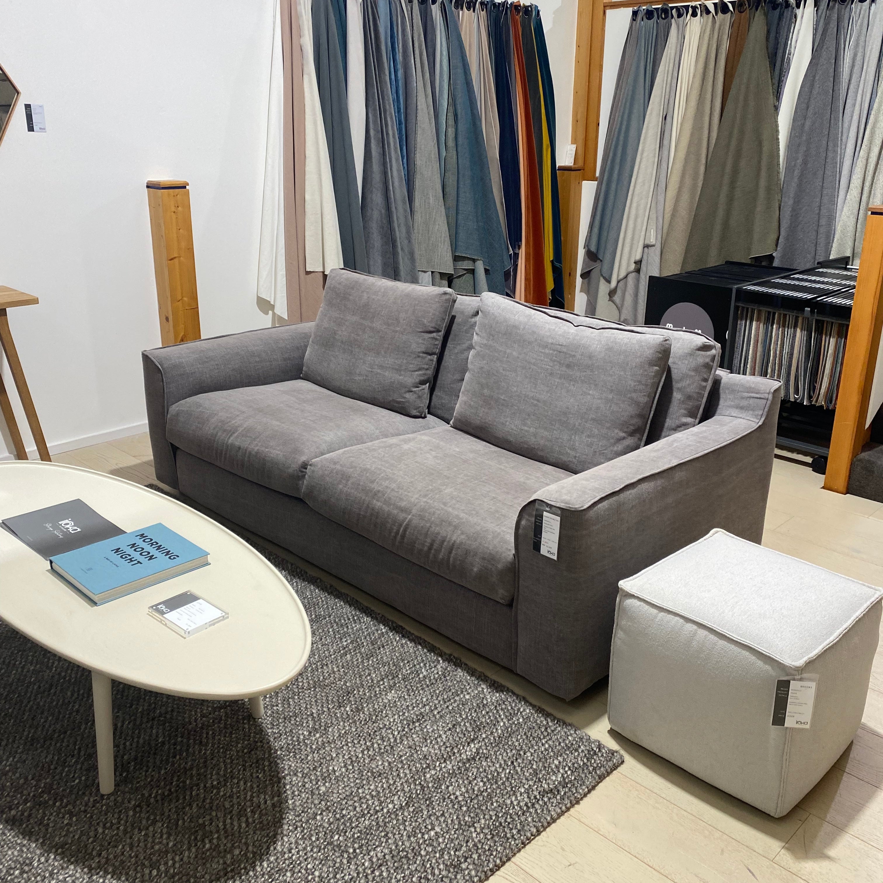 Gray sectional sofa in a showroom with color samples in the background