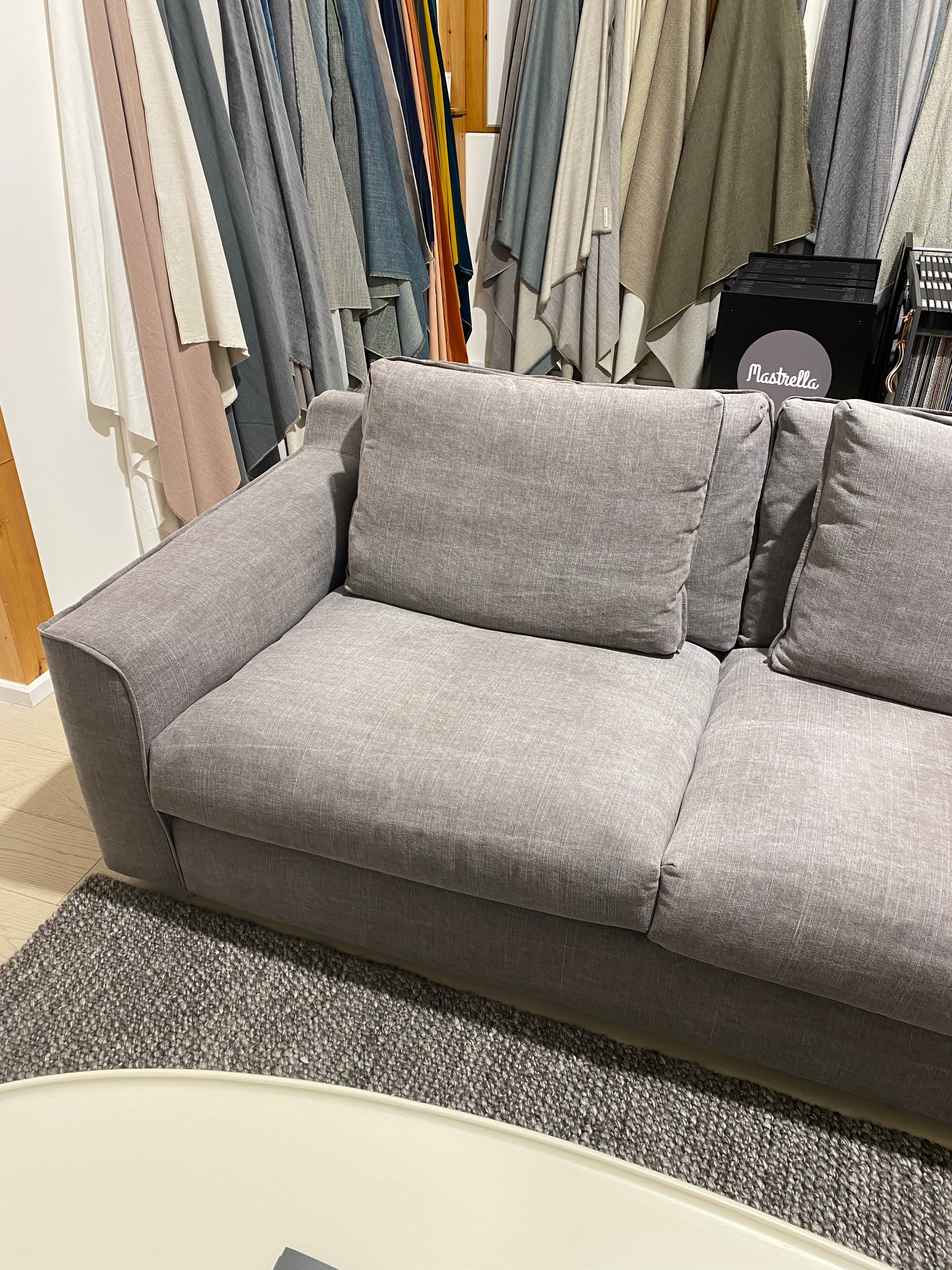 Gray upholstered headboard with fabric swatches in a room setting