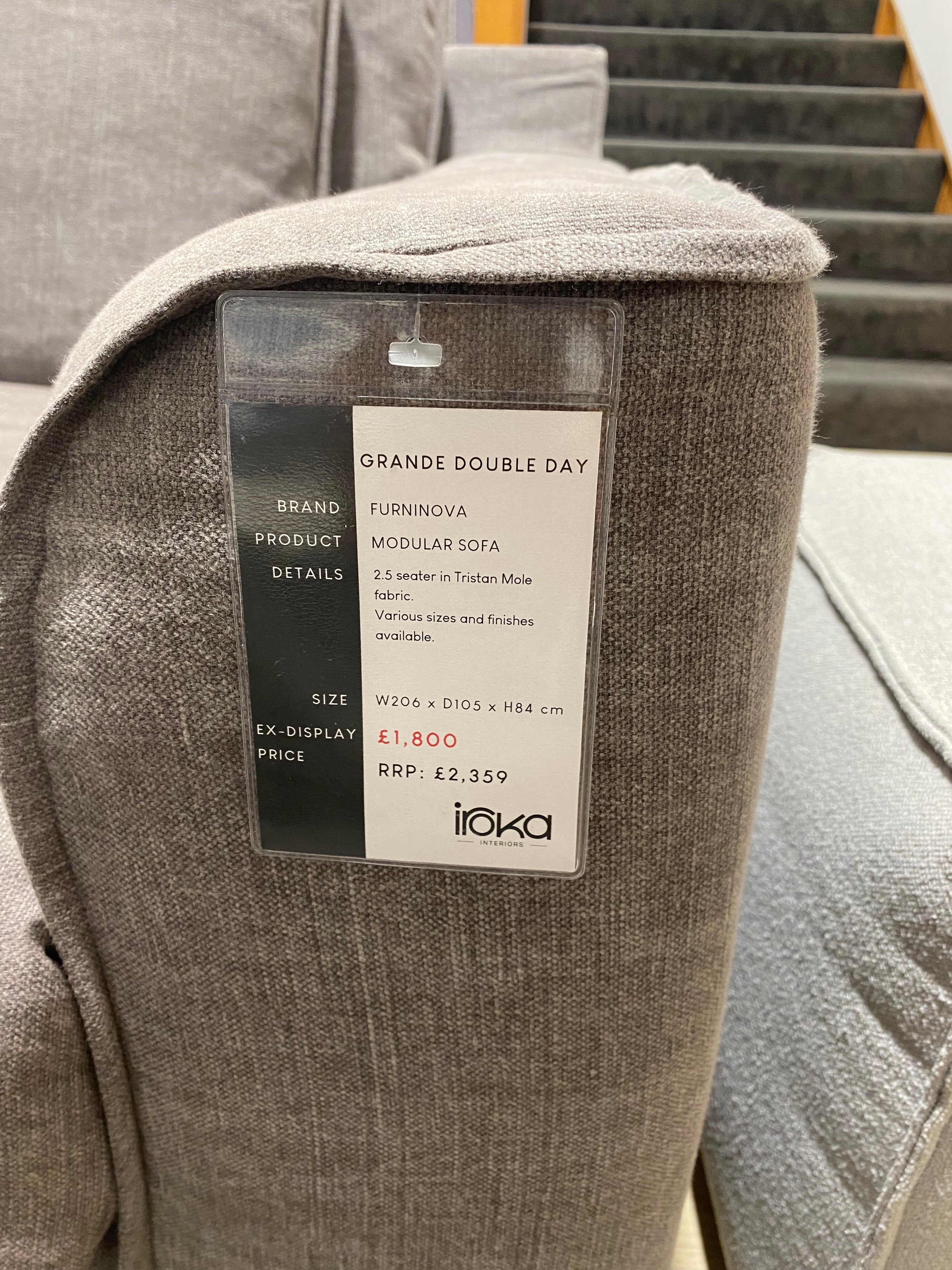 Grey sofa with a visible label on a blurred background
