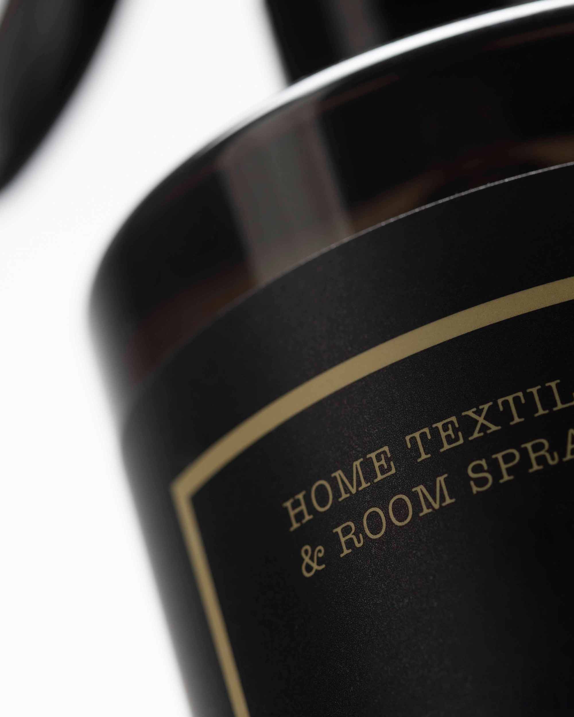 Close-up of a black bottle with gold text on a white background