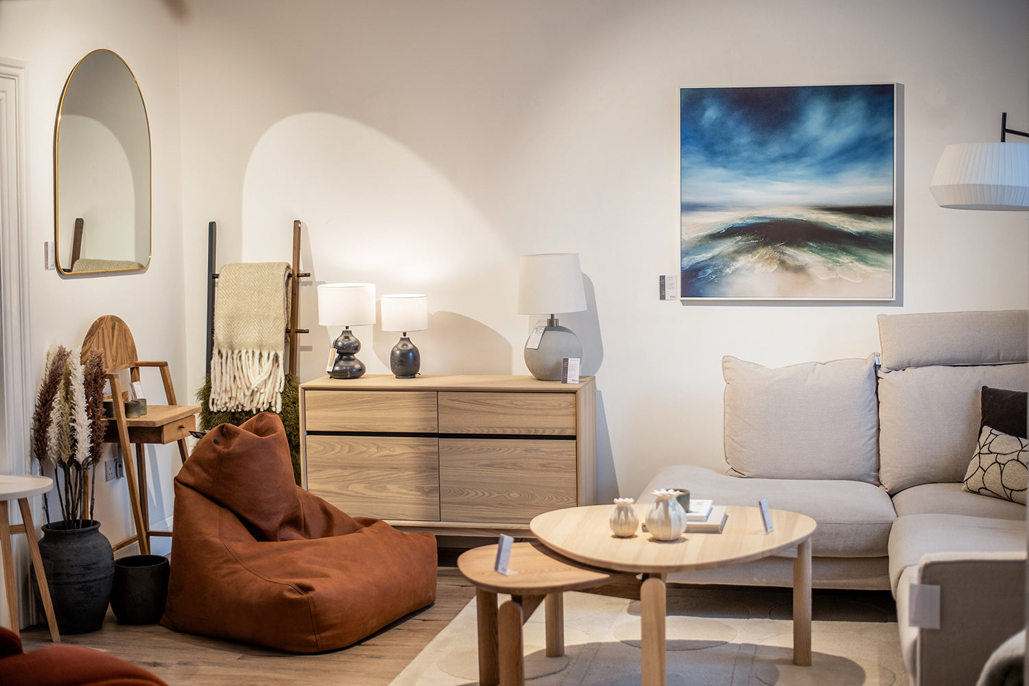 Living room set with warm natural tones. Seascape canvas print. Styled with neutral coloured homewares accessories.