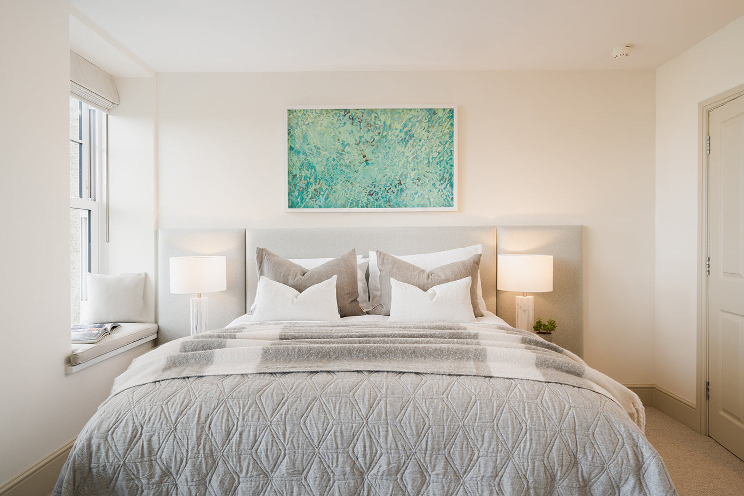 Bedroom Image at Seaglass House. Blue and green seascape artwork and grey interior styling.